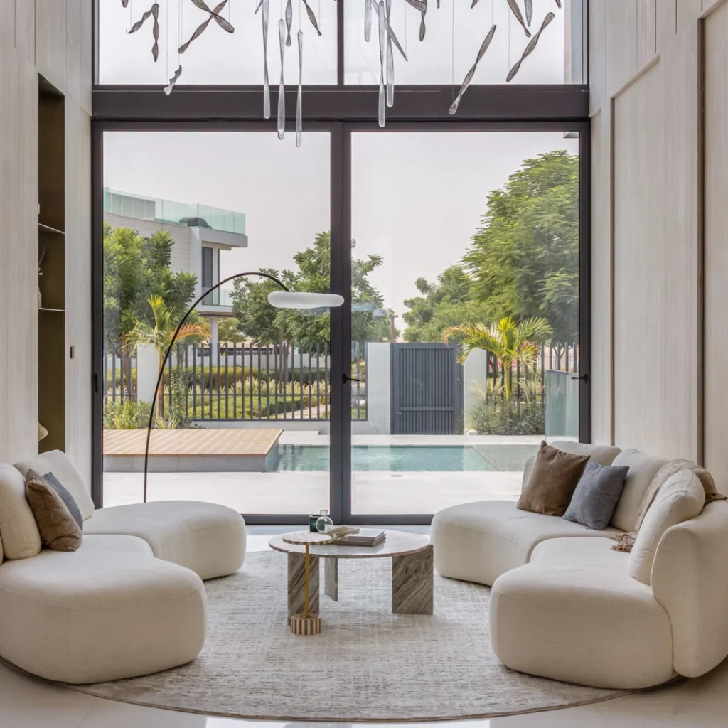 Villa renovation in Dubai with double-height lounge, floor-to-ceiling glazing and pool views