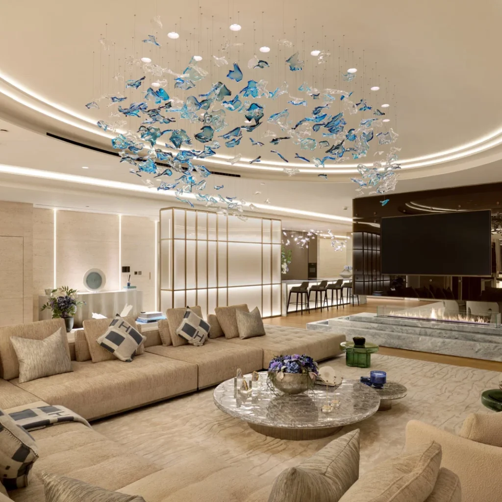 Apartment renovation in Dubai living room with sectional seating, marble fireplace and decorative ceiling installation