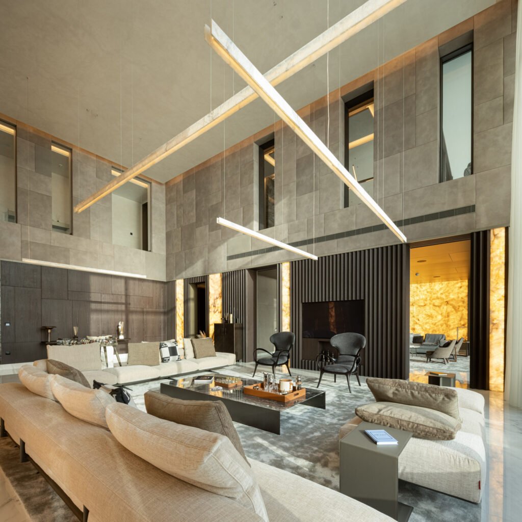 High-end villa fit out in Dubai featuring a double-height lounge with stone walls and architectural lighting