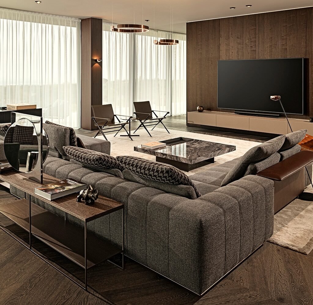 Apartment interior design in Dubai featuring a spacious grey sectional sofa, dark wood TV wall and contemporary furniture