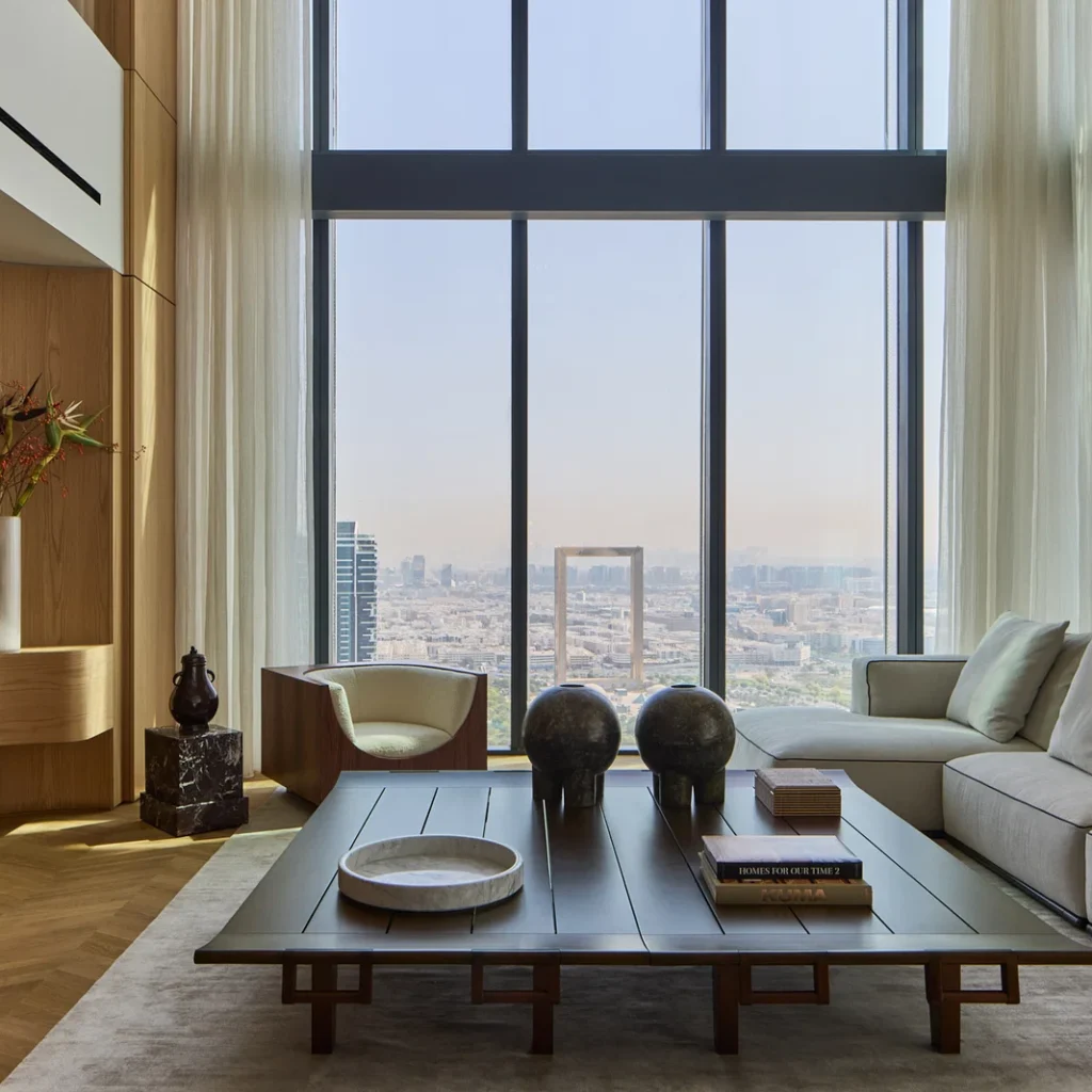 Penthouse living room design in Dubai with double-height windows, contemporary furniture and panoramic skyline views