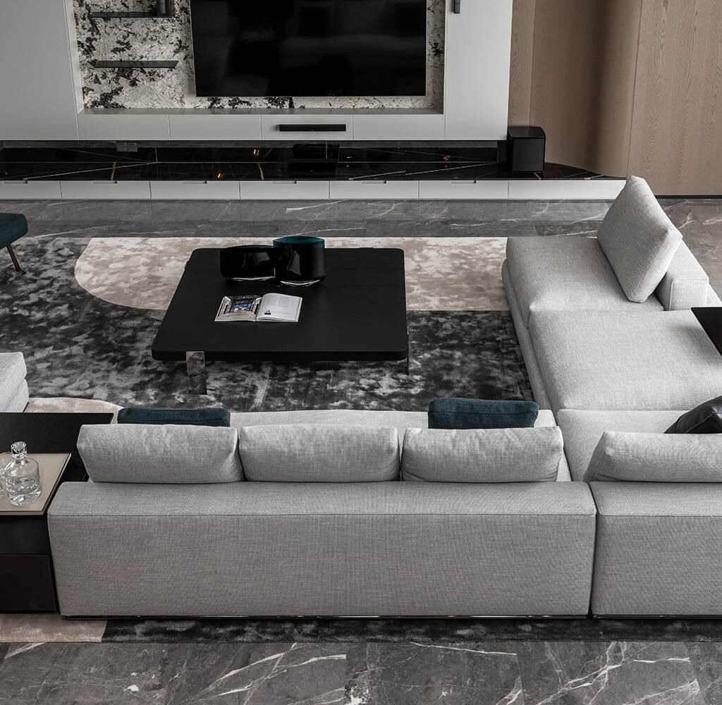 Penthouse living room interior design in Dubai with grey sectional sofas, stone flooring and a modern TV wall