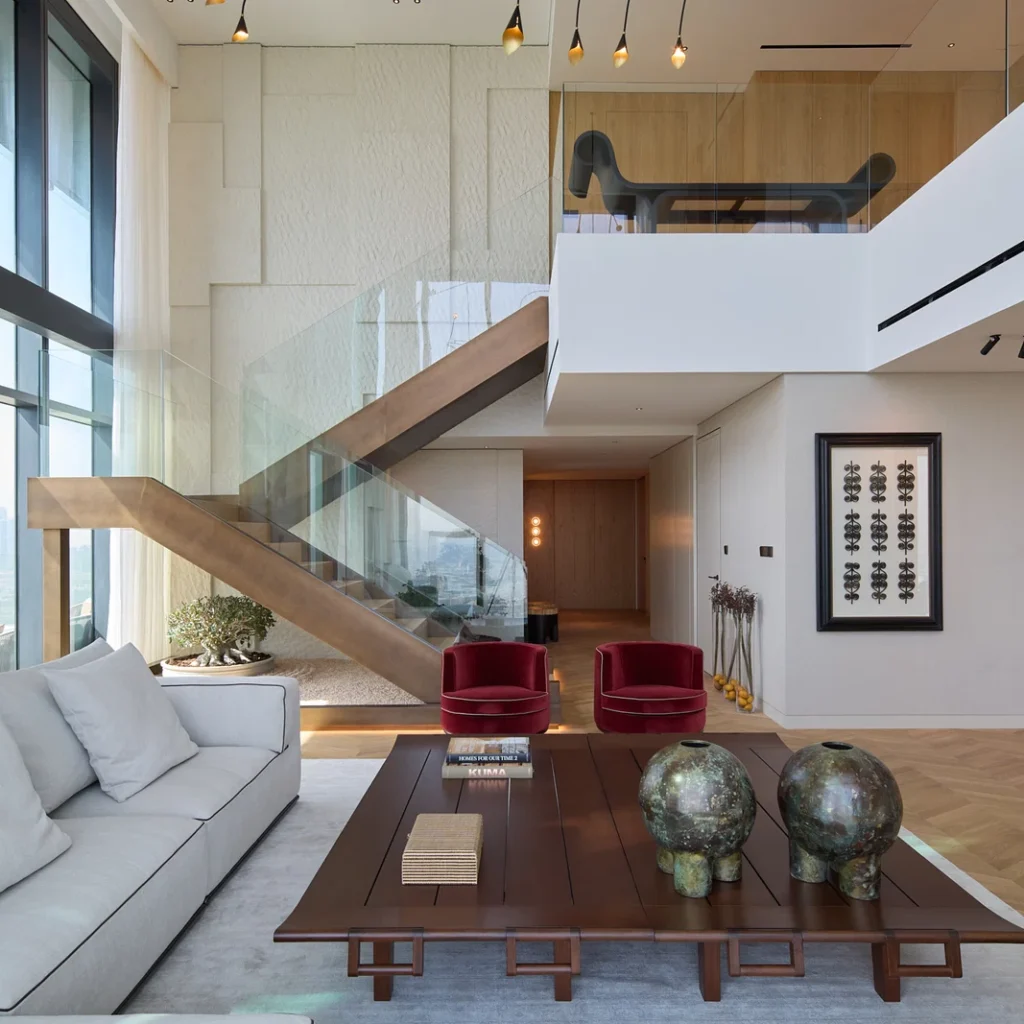 Duplex penthouse interior design in Dubai featuring a modern internal staircase, double-height lounge and contemporary furniture