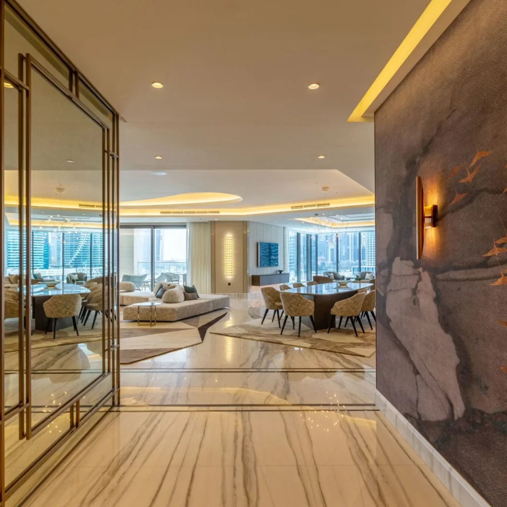 Apartment fit out in Dubai featuring marble flooring, custom wall finishes and an open-plan living and dining area