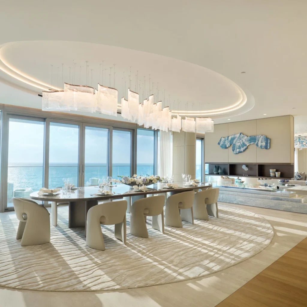Apartment renovation in Dubai featuring a sea view dining room with contemporary furniture and statement lighting