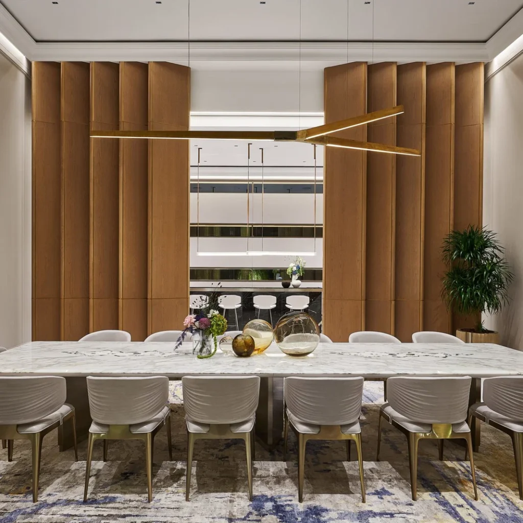 Villa renovation in Dubai dining room with marble table, timber wall panels and statement lighting