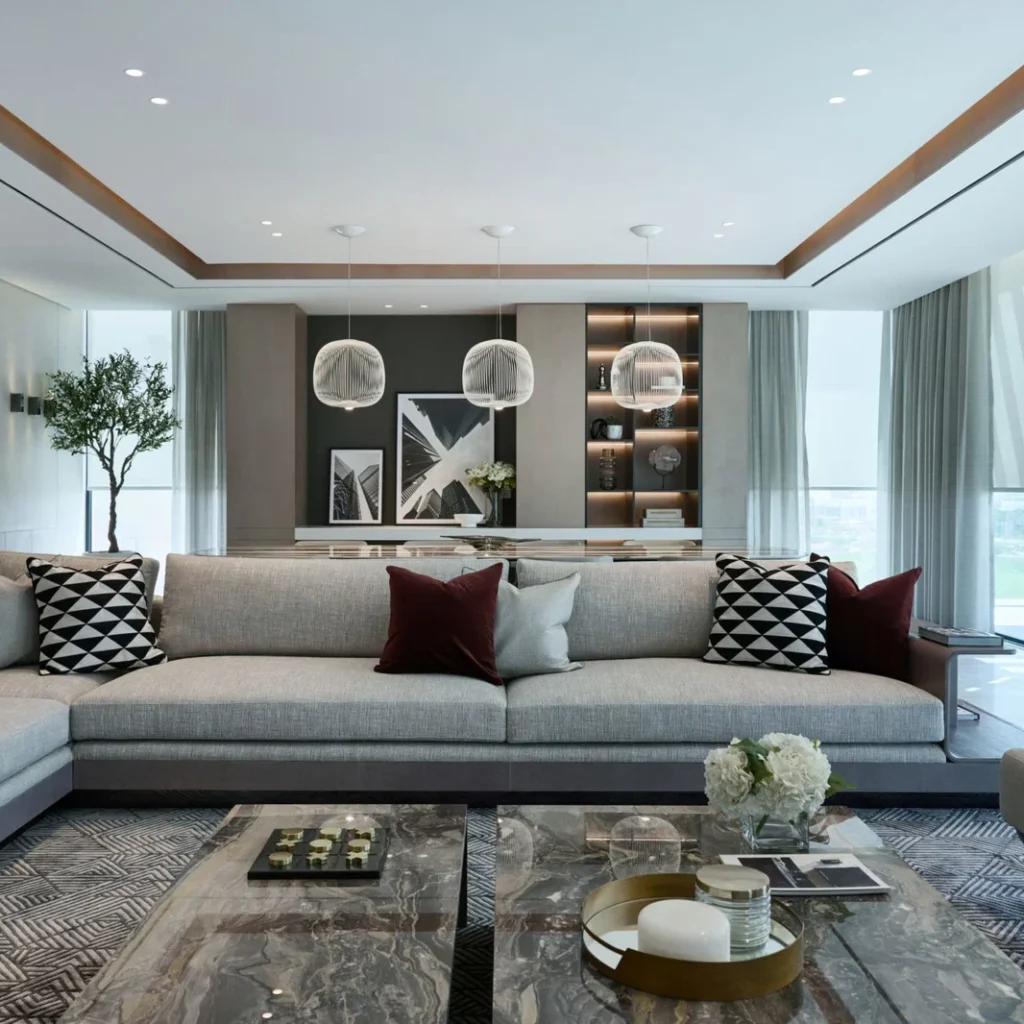 High-end penthouse living room design in Dubai with a large sectional sofa, marble tables and pendant lighting