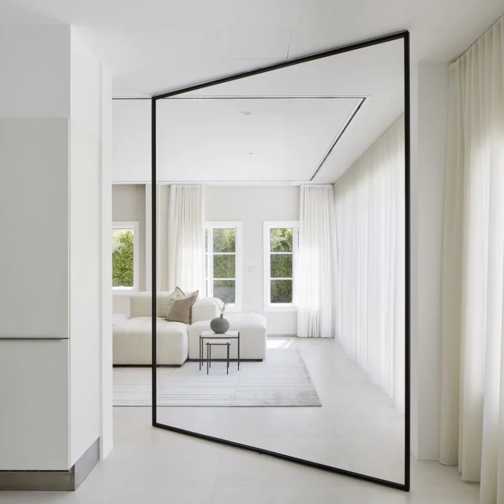 Modern apartment fit out in Dubai featuring a floor-to-ceiling feature mirror, bright living space and minimalist finishes