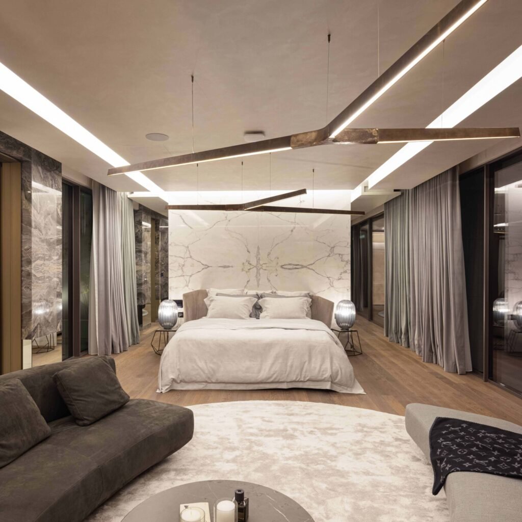 Villa bedroom fit out in Dubai featuring a marble feature wall, wood flooring and integrated lighting