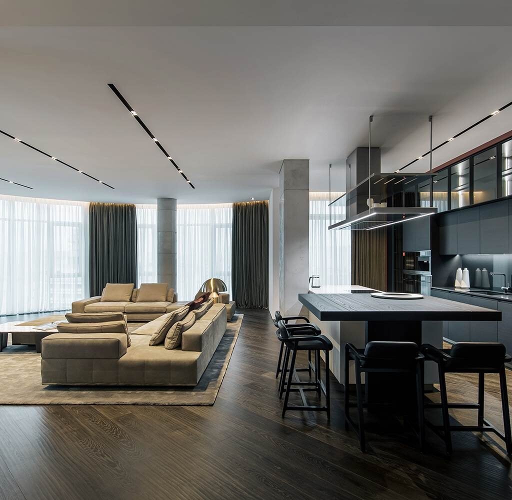 Penthouse kitchen fit out in Dubai featuring custom dark cabinetry, island seating and an open-plan living area