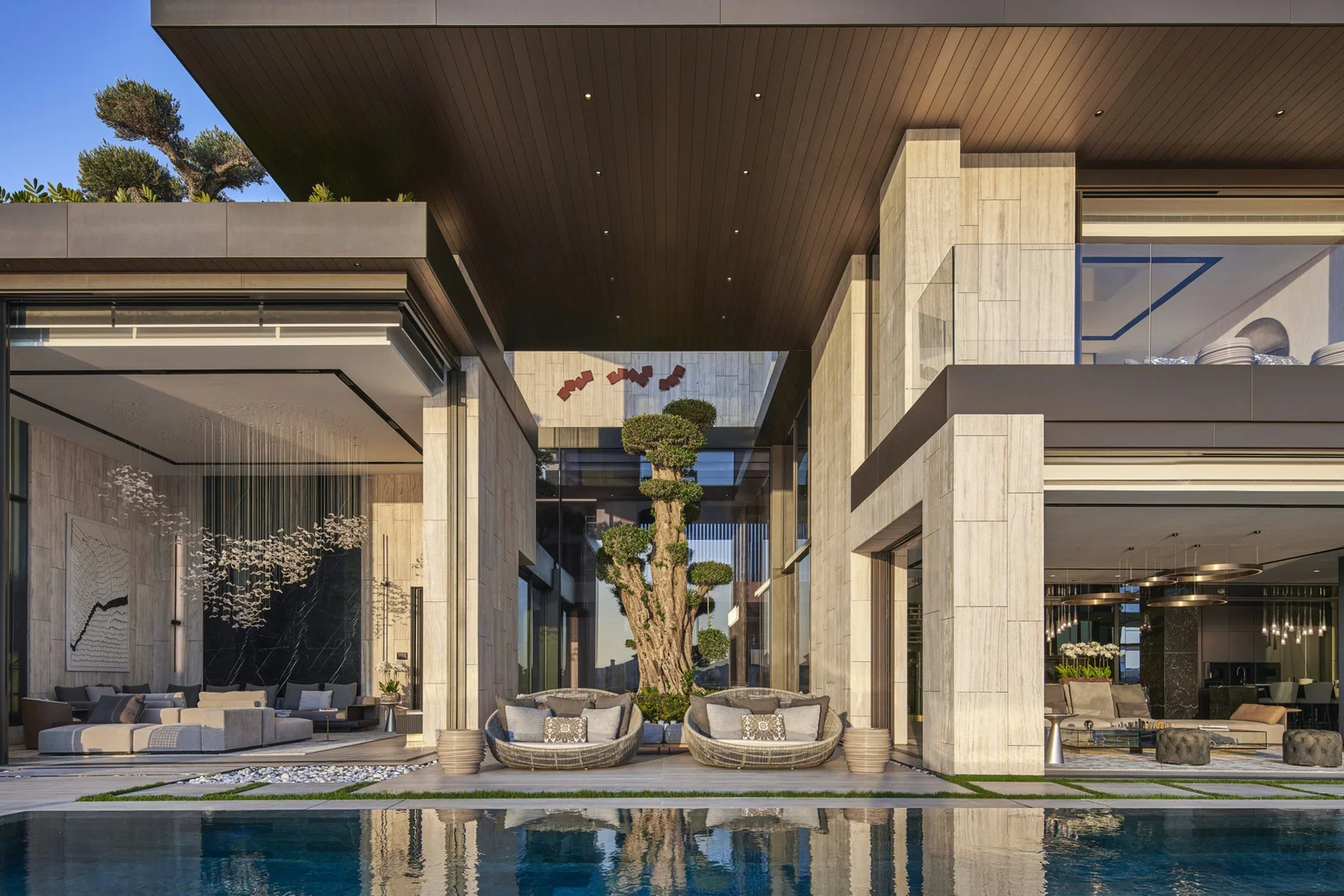 Contemporary villa with stone-clad columns, open living spaces and poolside seating