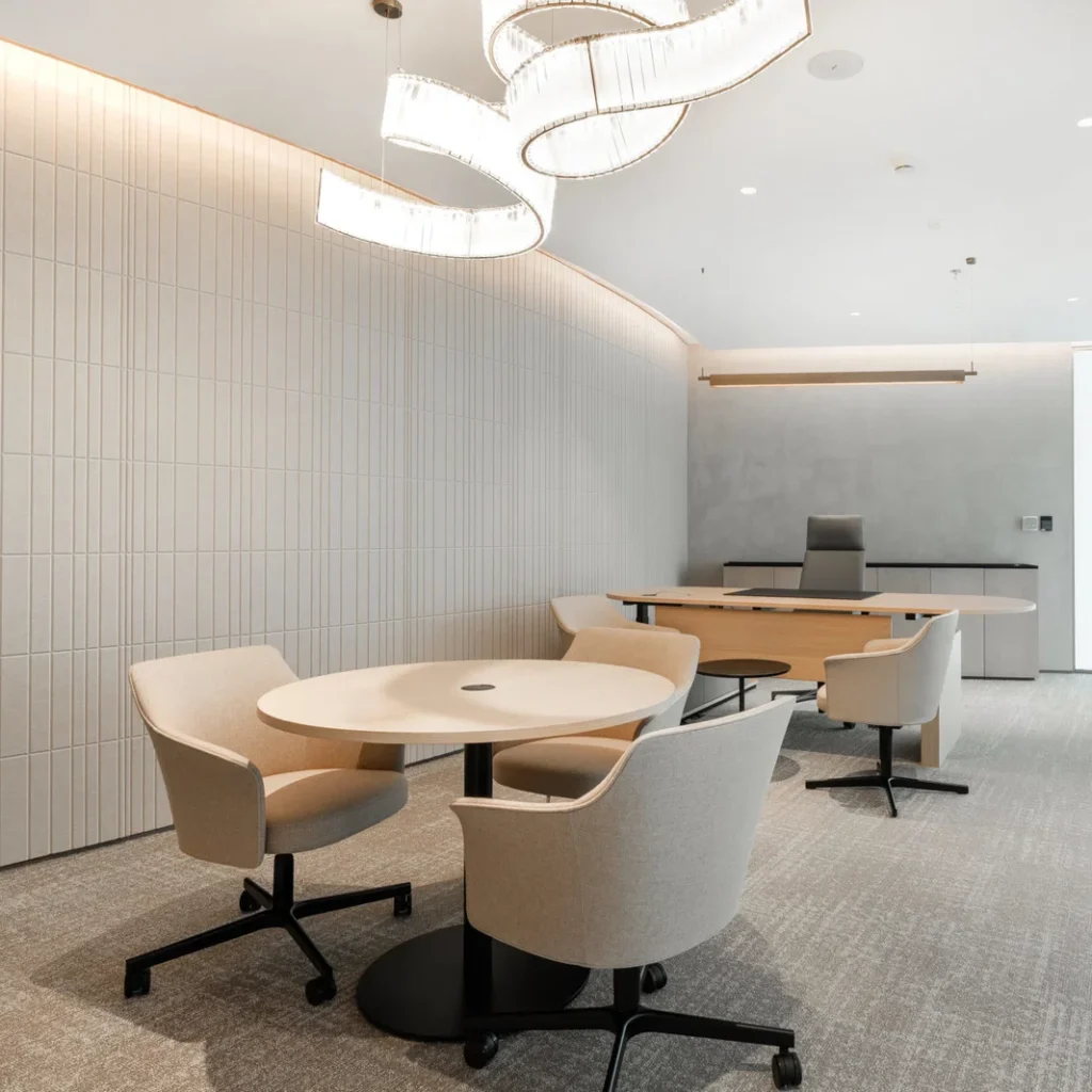 Commercial office interior design in Dubai with a modern meeting area, executive desk and statement lighting