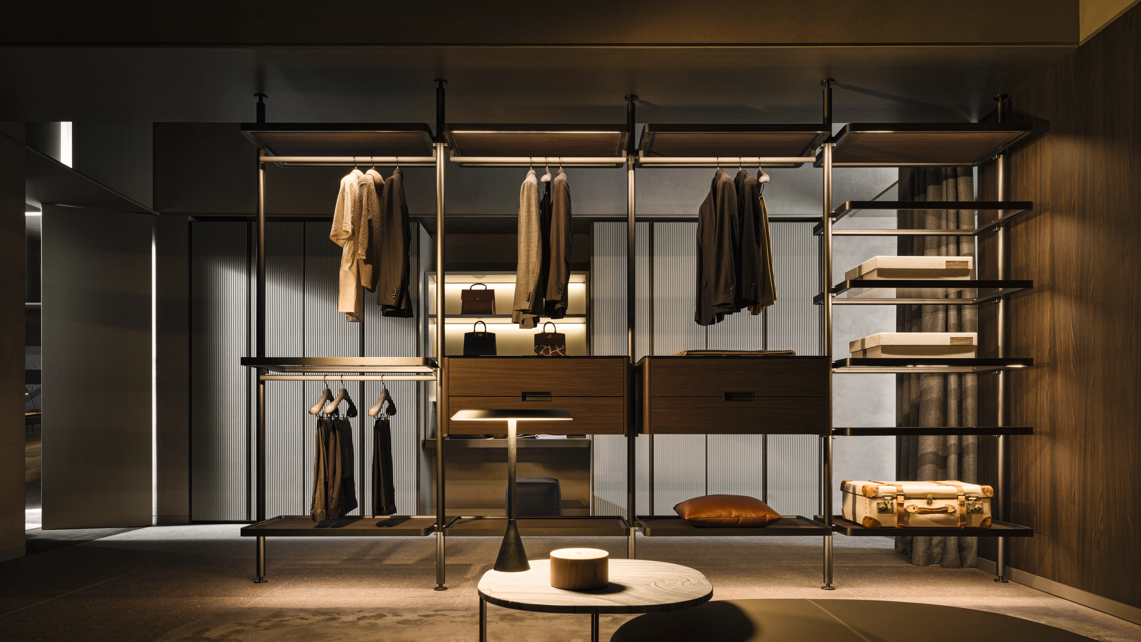 Open closet system with slim metal posts, hanging rails, suspended wood drawers and shelves for boxes and luggage.