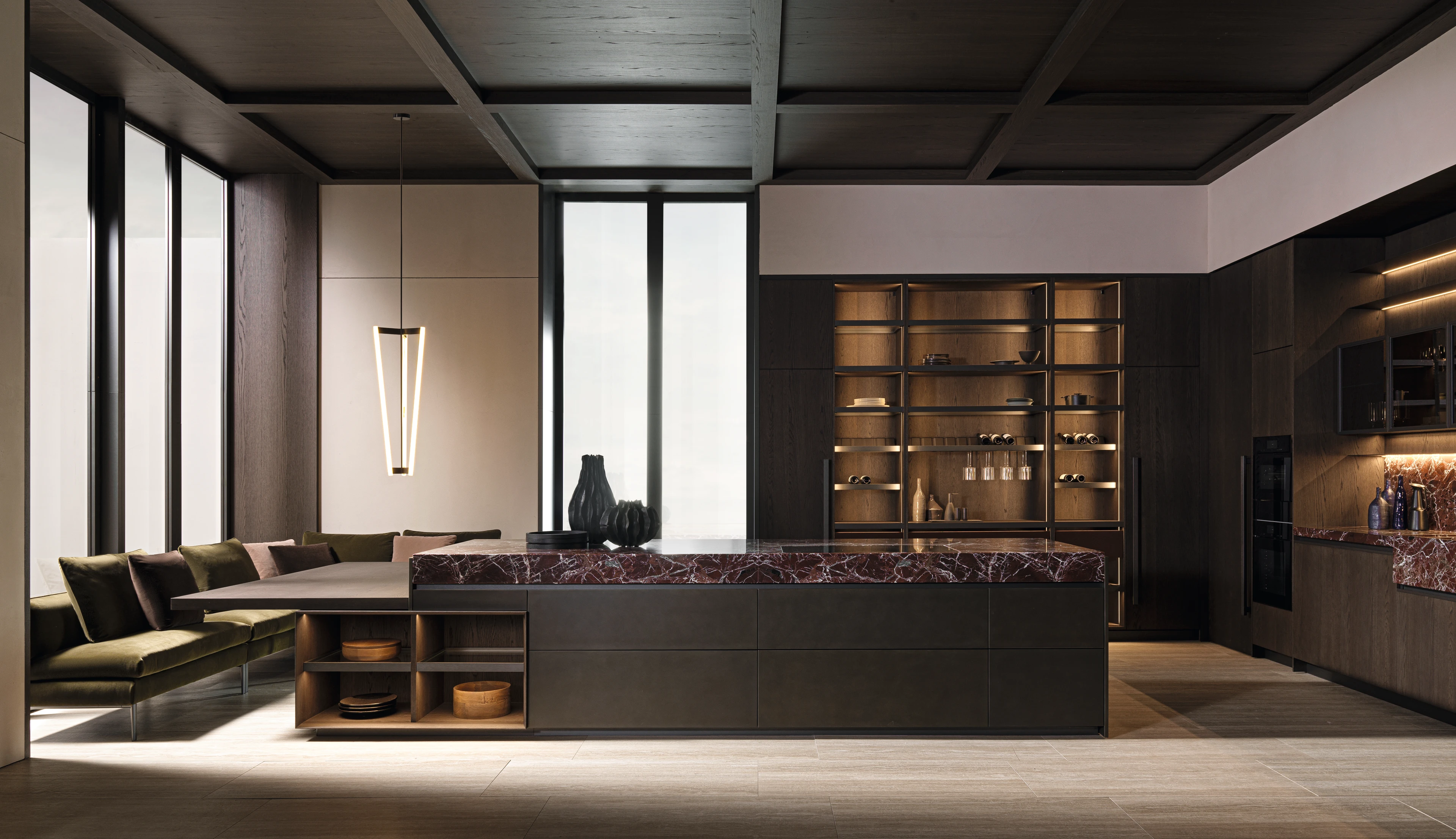 Kitchen with a burgundy veined island, adjoining dining table, green bench seating and illuminated display cabinets.