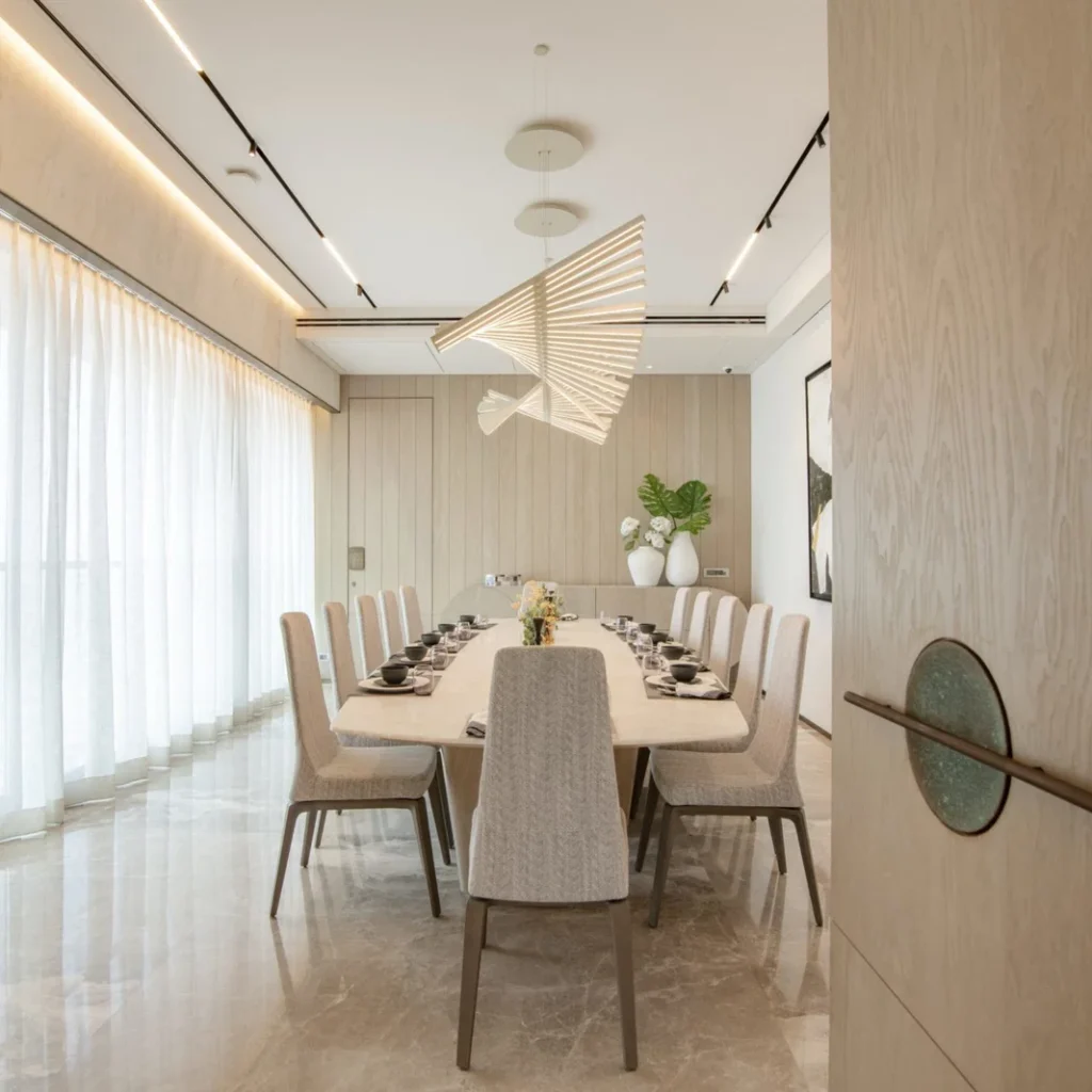 Penthouse renovation in Dubai featuring a formal dining room with contemporary seating and sculptural pendant lighting